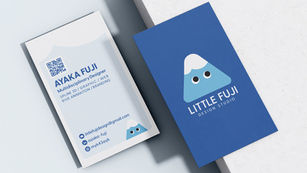 Two business cards on a light surface; one white with contact info and design services, the other blue with a cute mountain logo, "LITTLE FUJI."