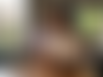 Mujer joven en una cafetería revisando su celular, del cual se proyecta una interfaz holográfica que muestra una gráfica financiera de rendimientos.