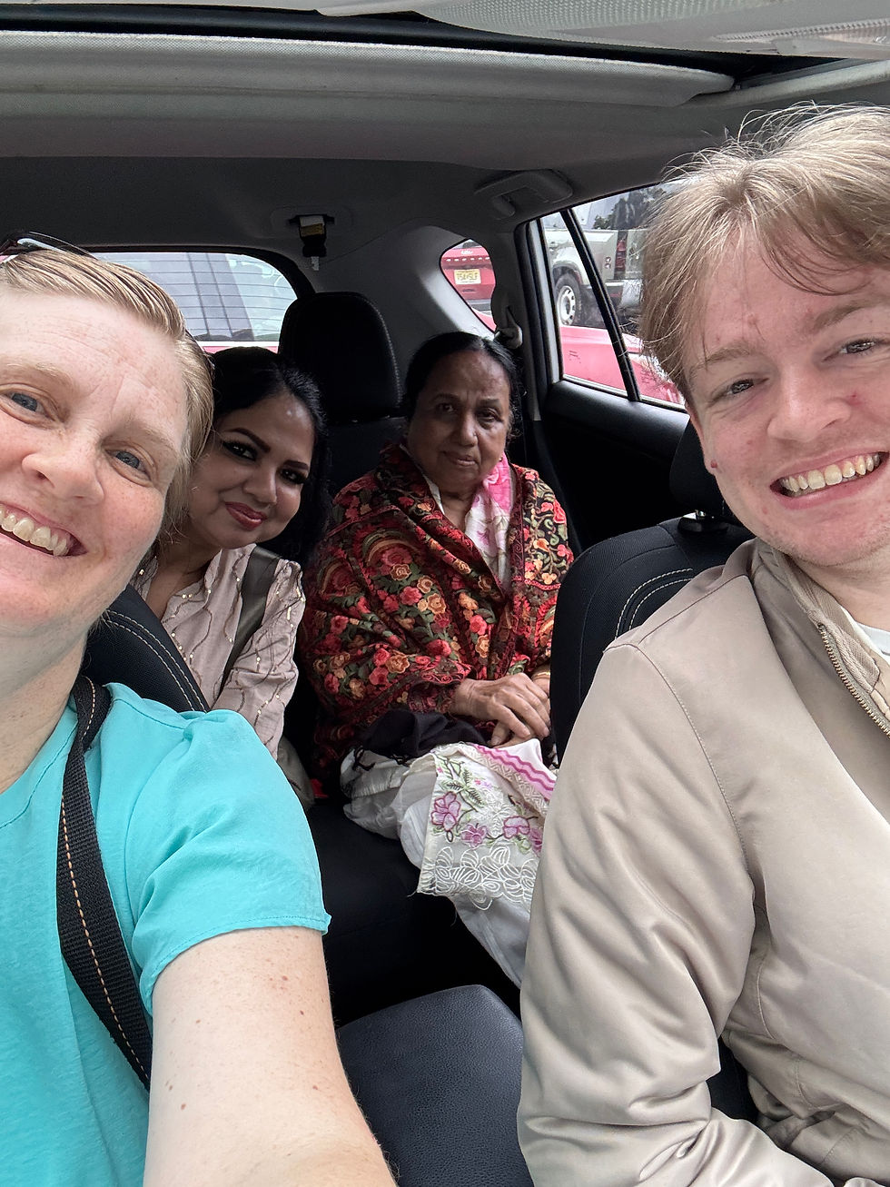 Four people pose for a selfie in a car.