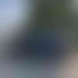 A blue Subaru Outback with a silver Grumman canoe on top is parked at Ottawa Lake, Wisconsin.