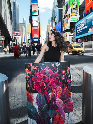 Artist holding large floral painting in Times Square, New York City