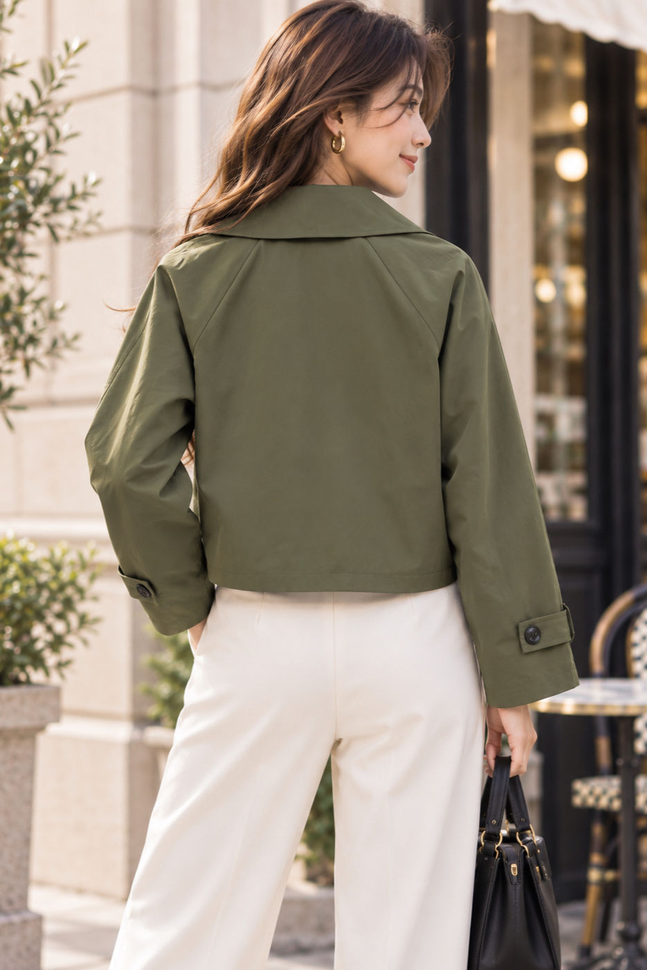 Back view of olive green cropped trench jacket showing collar and cropped hem