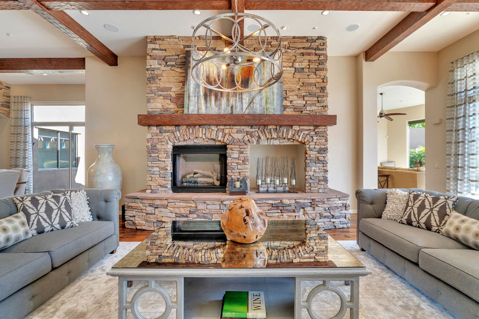 Stack stone fireplace, mirrored coffee table, wood ball sculpture, neutral living room, Scottsdale