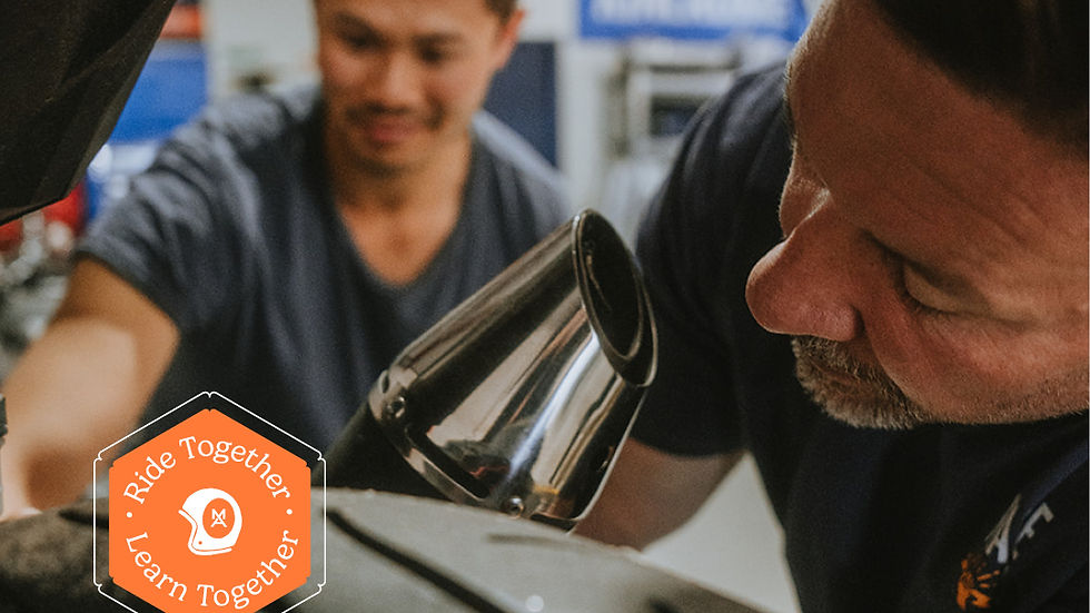 Two men servicing a motorcycle