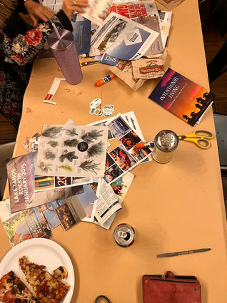 Scrapbooking materials and supplies on a table with pizza, scissors, and magazines.
