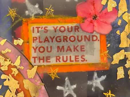 Text "It's your playground. You make the rules." on a colorful background with a pink flower, gold flakes, and star decorations. Vibrant mood. Mixed Media Encaustic