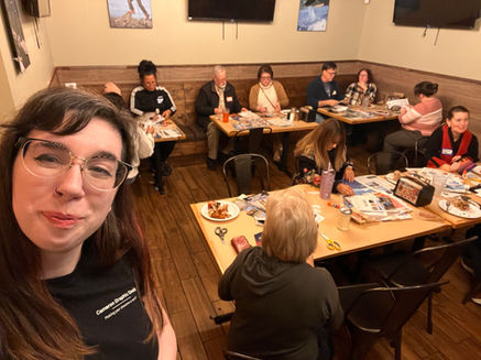 Katahrine takes selfie while others craft at tables inside a restaurant