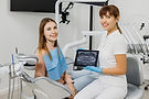 friendly_dentist_with_xray_picture_tablet_explaining_treatment_patient.jpg
