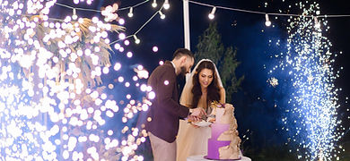 newlyweds-evening-celebration-wedding-cutting-cake-outdoors.jpg
