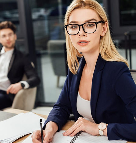 selective-focus-of-businessman-looking-at-businesswoman-in-eyeglasses-that-looking-at-came