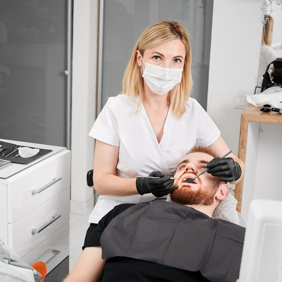 female-dentist-examining-man-teeth-dental-office.jpg