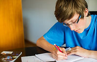 Smiling teenager studying and doing his