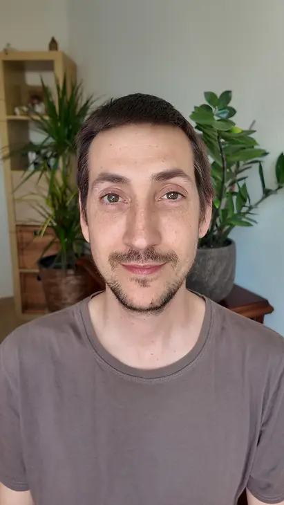 Porträt von Fabio Salvati, dem Berater für Lebensberatung bei IntuitivReflektiv, lächelnd vor Zimmerpflanzen.