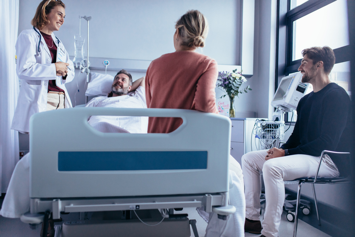Doctor speaking with patient and visitors in hospital