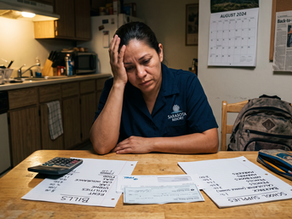 A working mother stressed as she looks at the school supply list and her monthly bills.