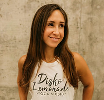 Yoga and Pilates instructor Angie Chapa of Disko Lemonade Yoga Studio smiling in front of concrete wall in Pensacola Florida