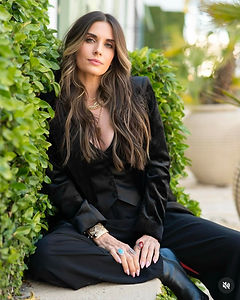 Sarah Paul of Sarah Knows Skin LLC in Inlet Beach, Florida, seated outdoors in a black outfit, representing skincare and facial services recommended by FIT30A.