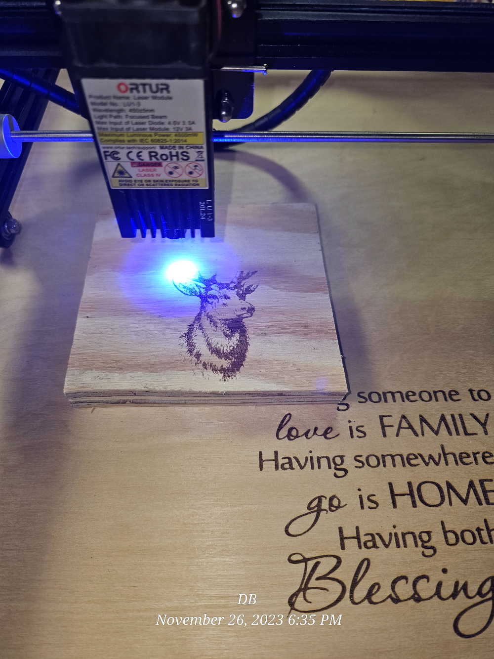 Laser engraver carving a deer onto wood