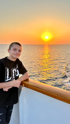 Boy on cruise ship at sunset, ocean view and family travel experience