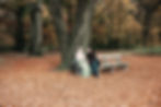 Female caregiver next to her mother in a wheelchair during Autumn with leaves on the groun