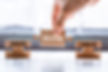 Hand holding a wooden puzzle with the word solution. There is a matching puzzle next to it