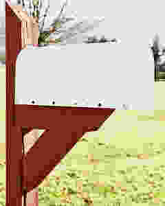 White mailbox on red pole before picture.