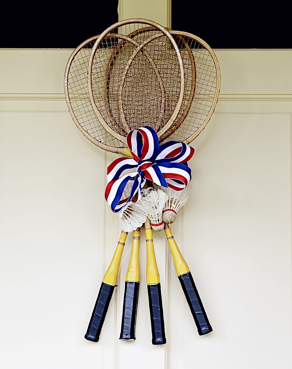 Vintage badminton racquets with vintage birdies and red, white and blue ribbon.