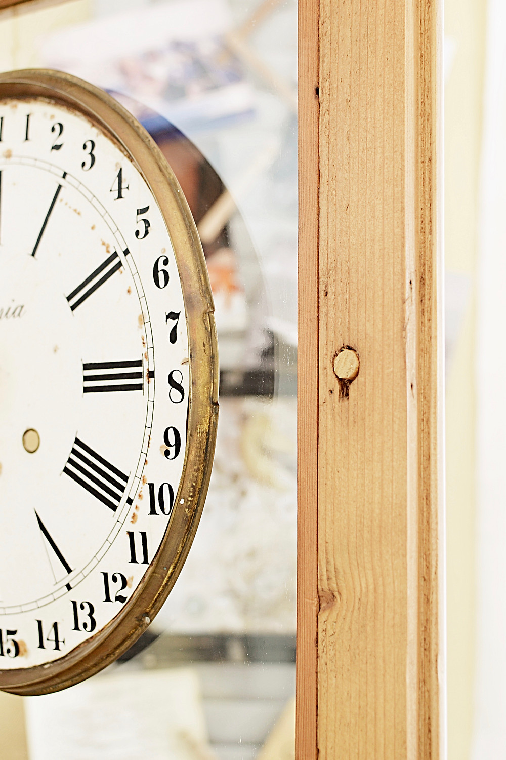 Vintage clock face on vintage wooden hutch glass door.