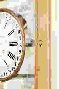 Vintage clock face on vintage wooden hutch glass door.