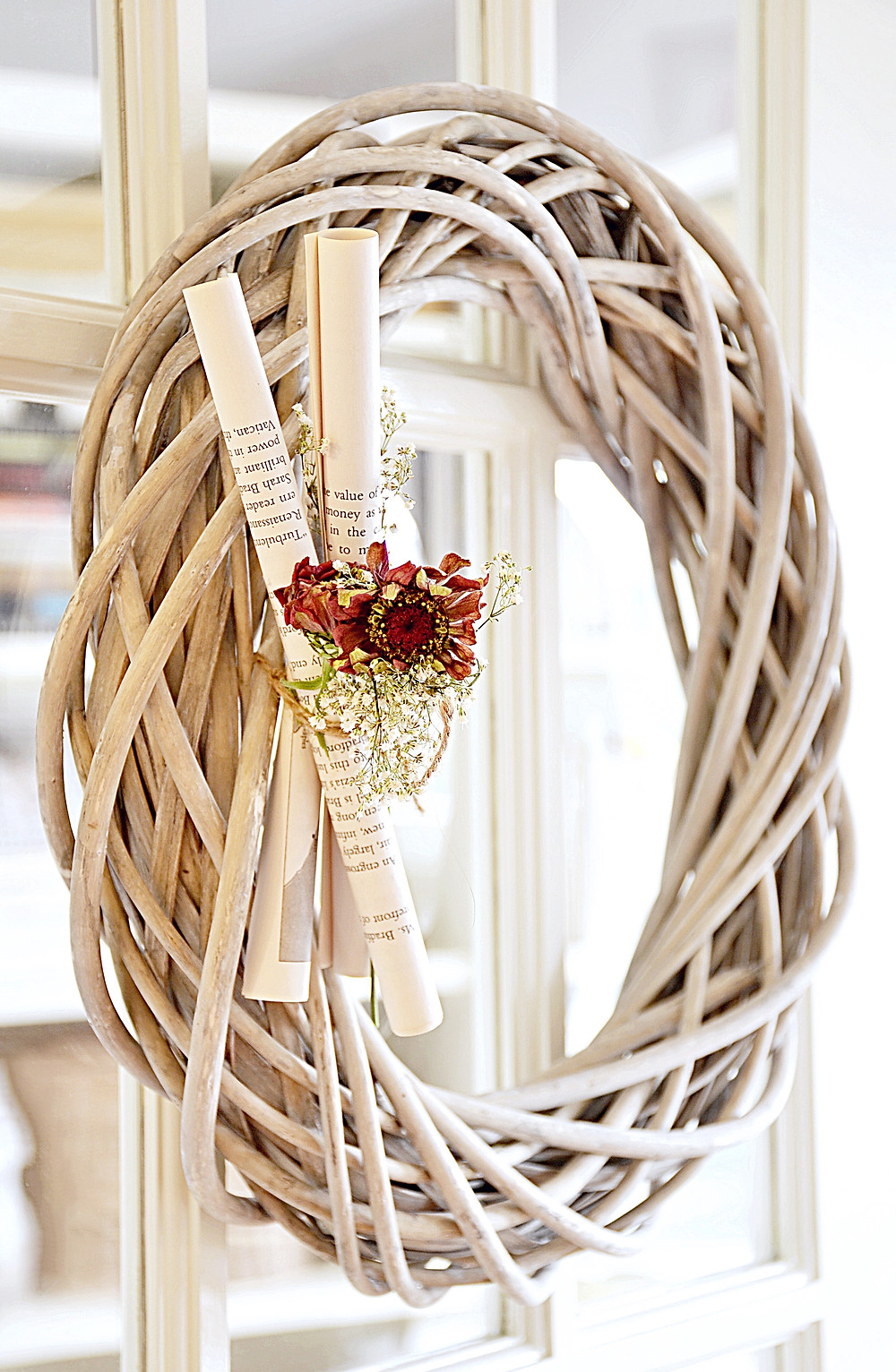 Wooden wreath with book pages and flowers.