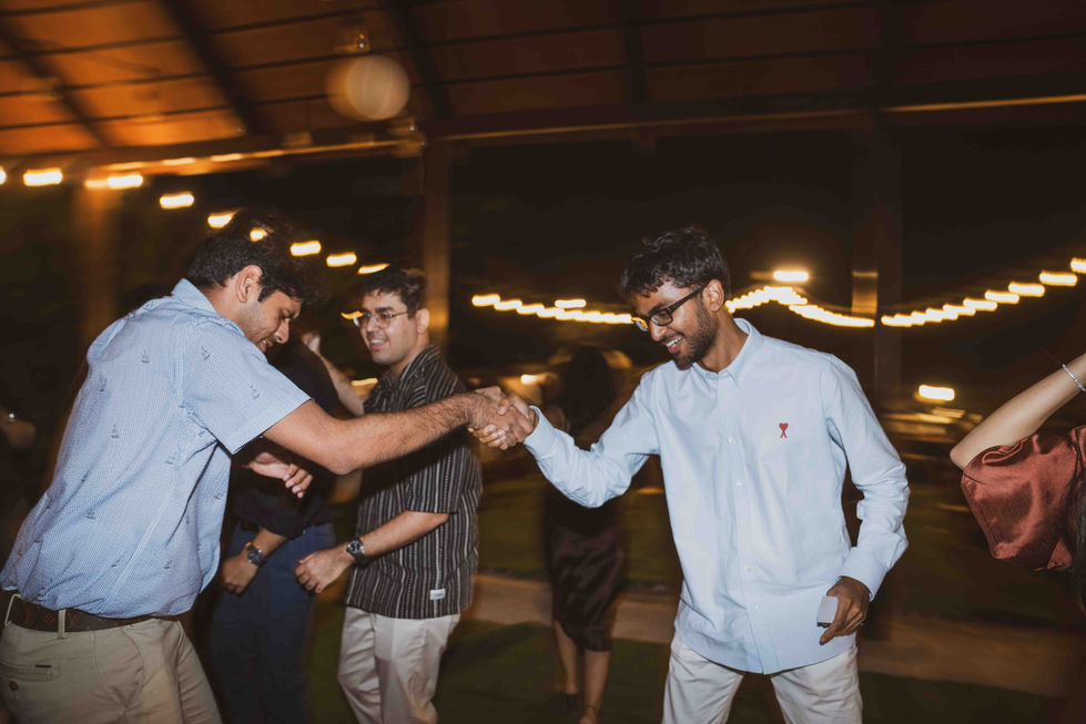 People dancing at an outdoor event, warmly lit atmosphere.