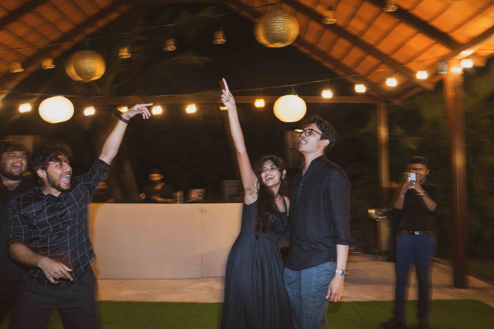 People dancing under string lights at an outdoor event.