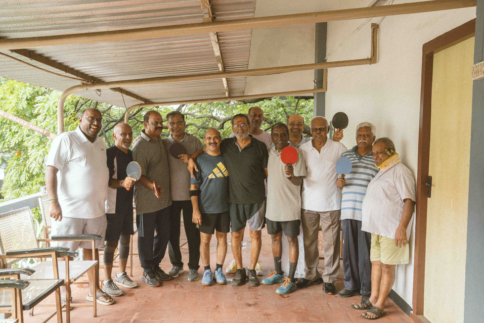 Group of people holding table tennis paddles, smiling.