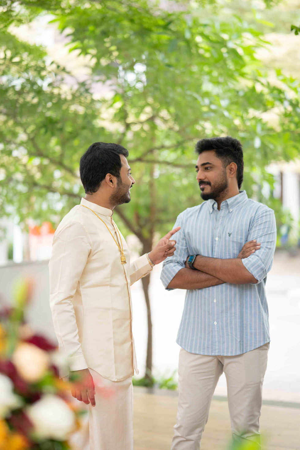 Two men talking outdoors, one gesturing animatedly.