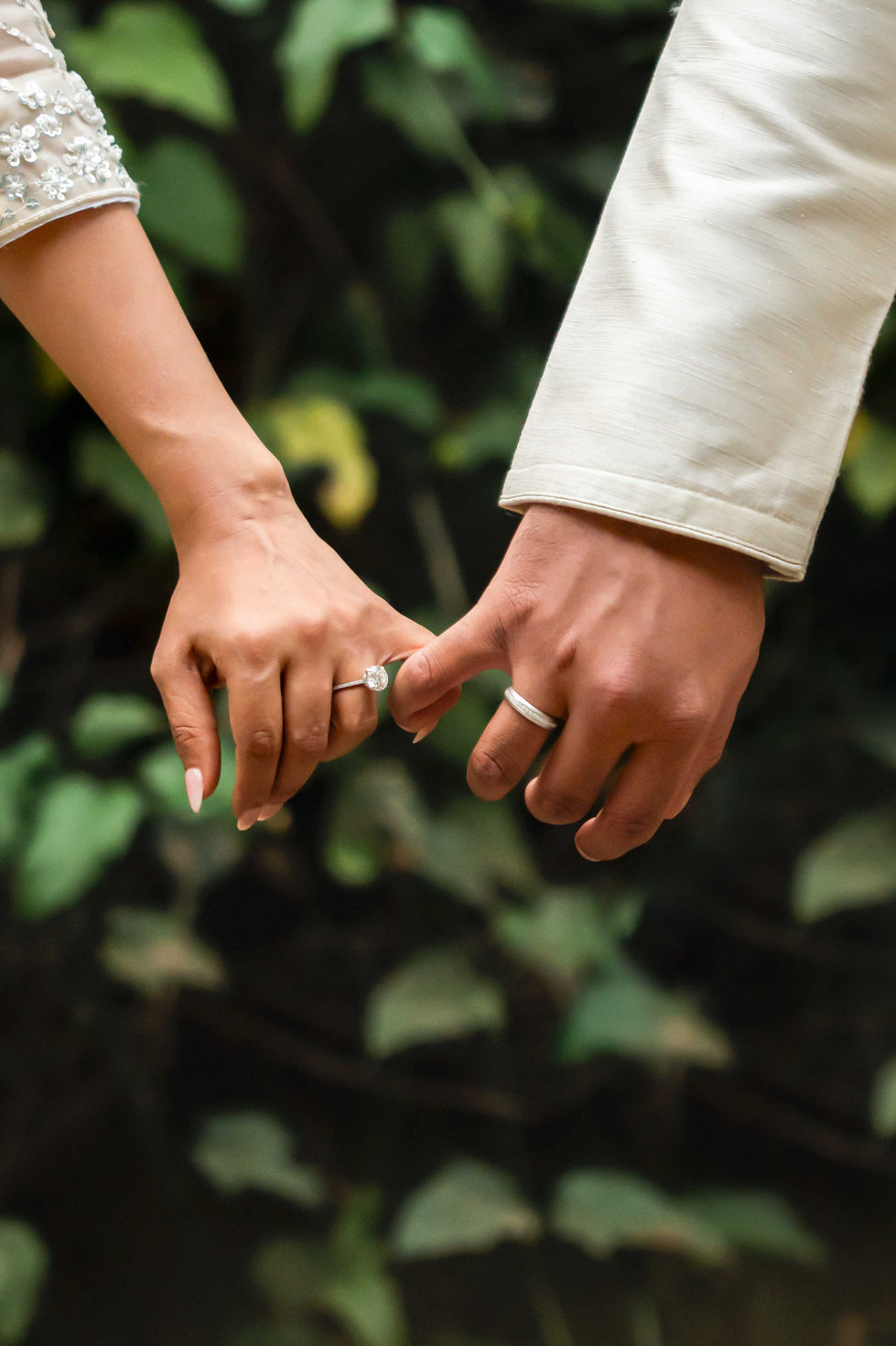 Two hands with rings, pinky promise gesture.