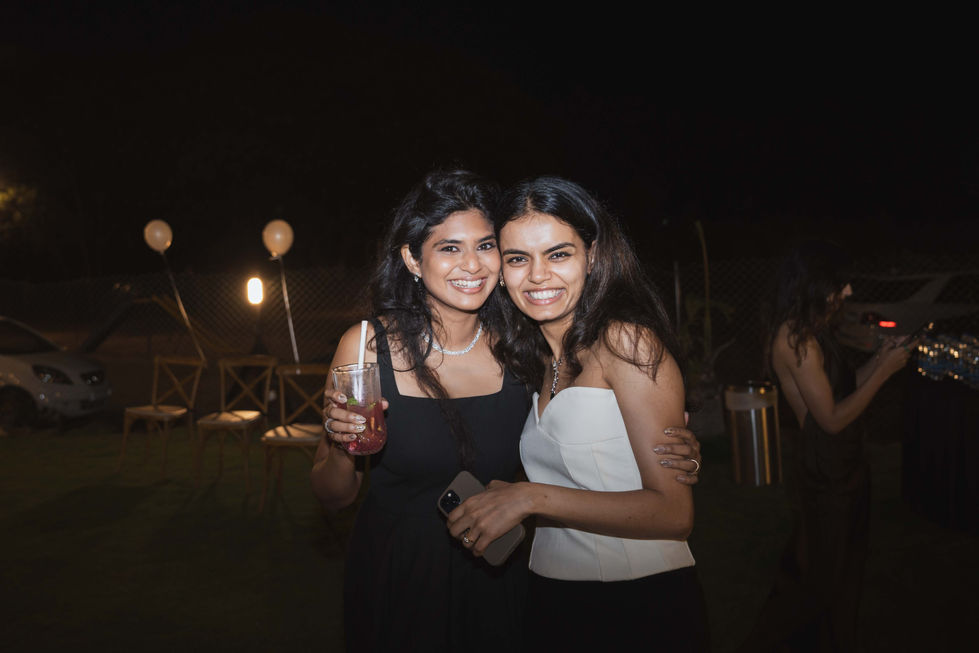 Two people smiling and embracing at an outdoor event.