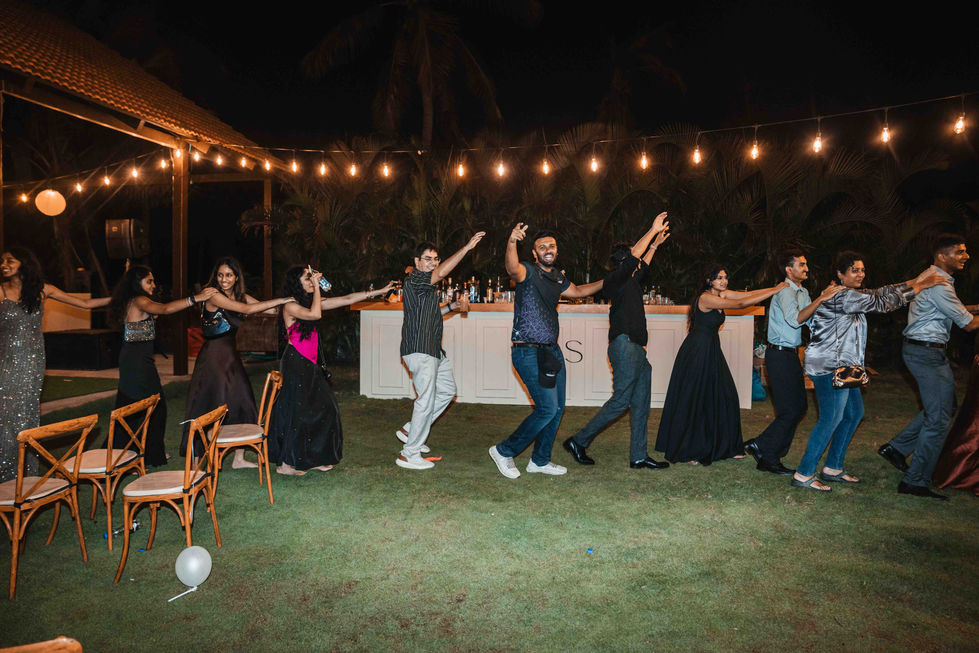 People dancing in a line at an outdoor event.