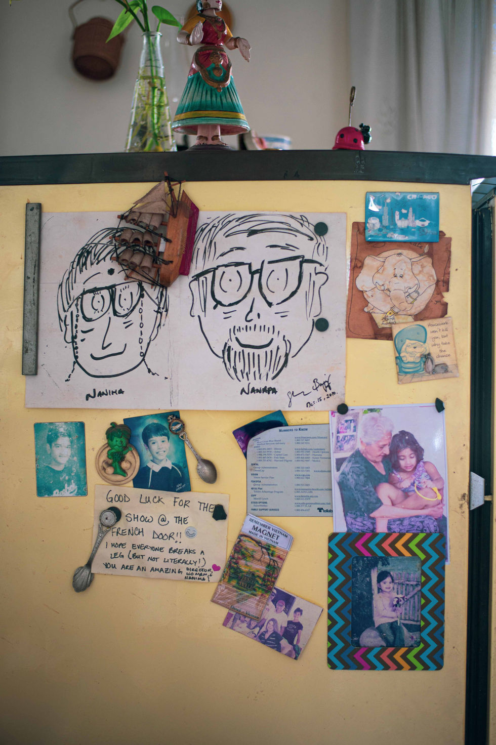 Refrigerator door with drawings and photos displayed.