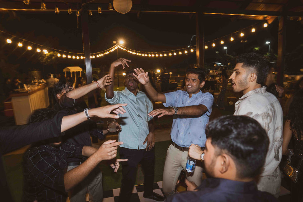 People dancing energetically at a nighttime outdoor event.
