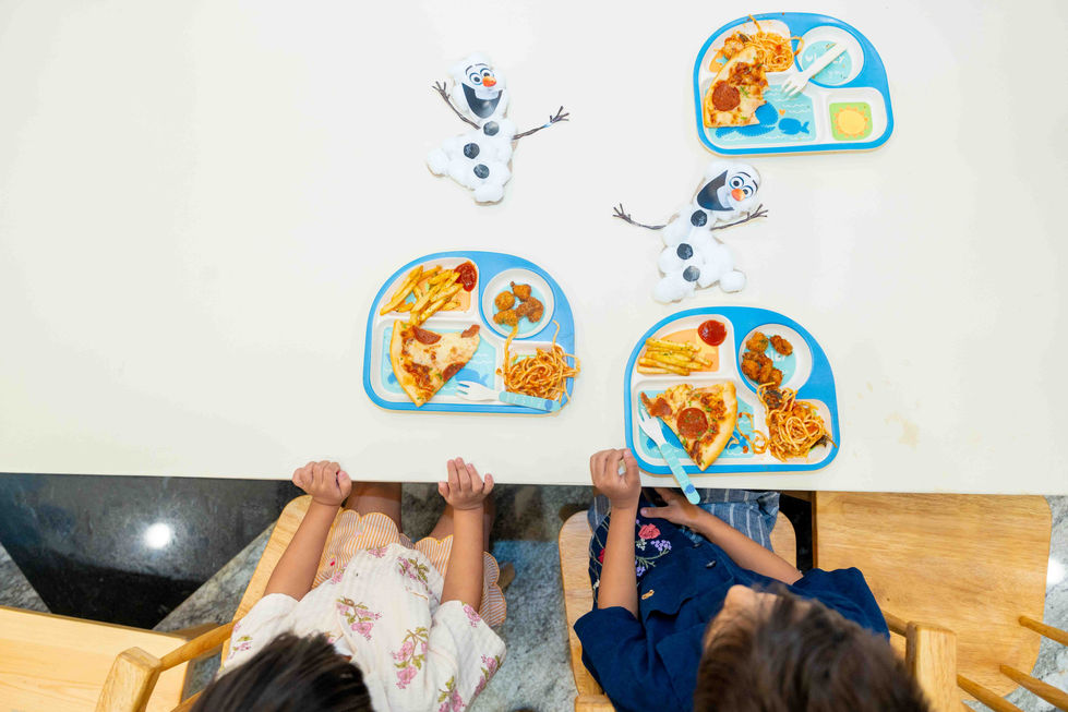 Children eating at table with Olaf-themed placemats.