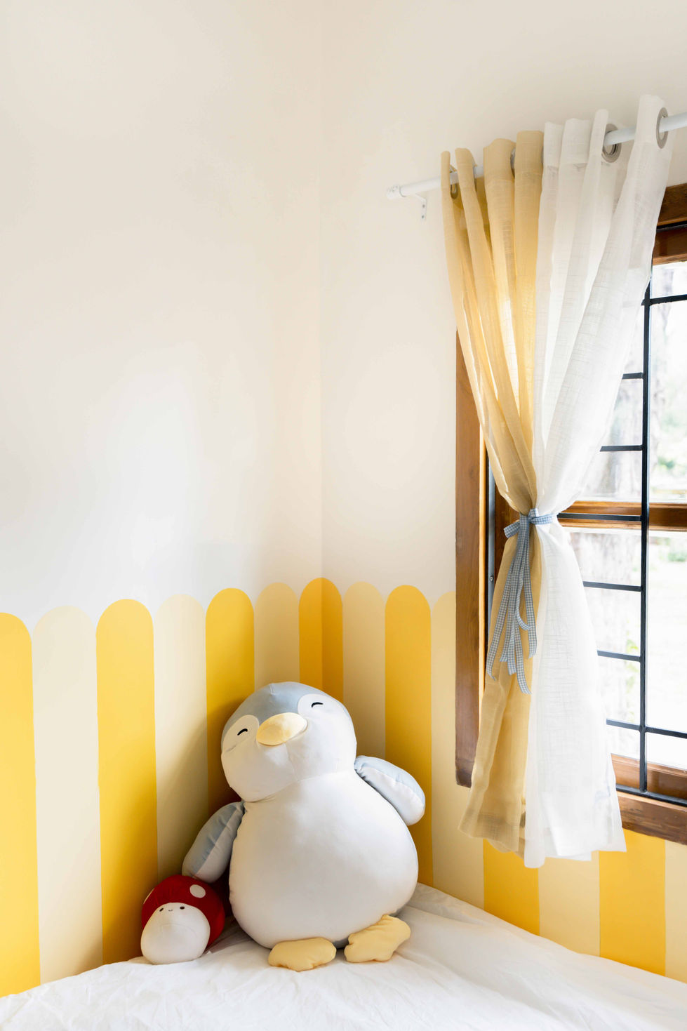 Stuffed penguin toy in a bright, cozy room.