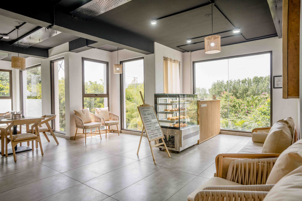 Modern cafe interior with large windows and seating.