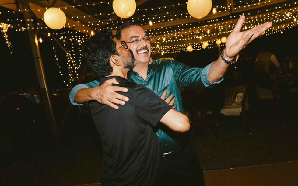 Two people dancing under string lights.