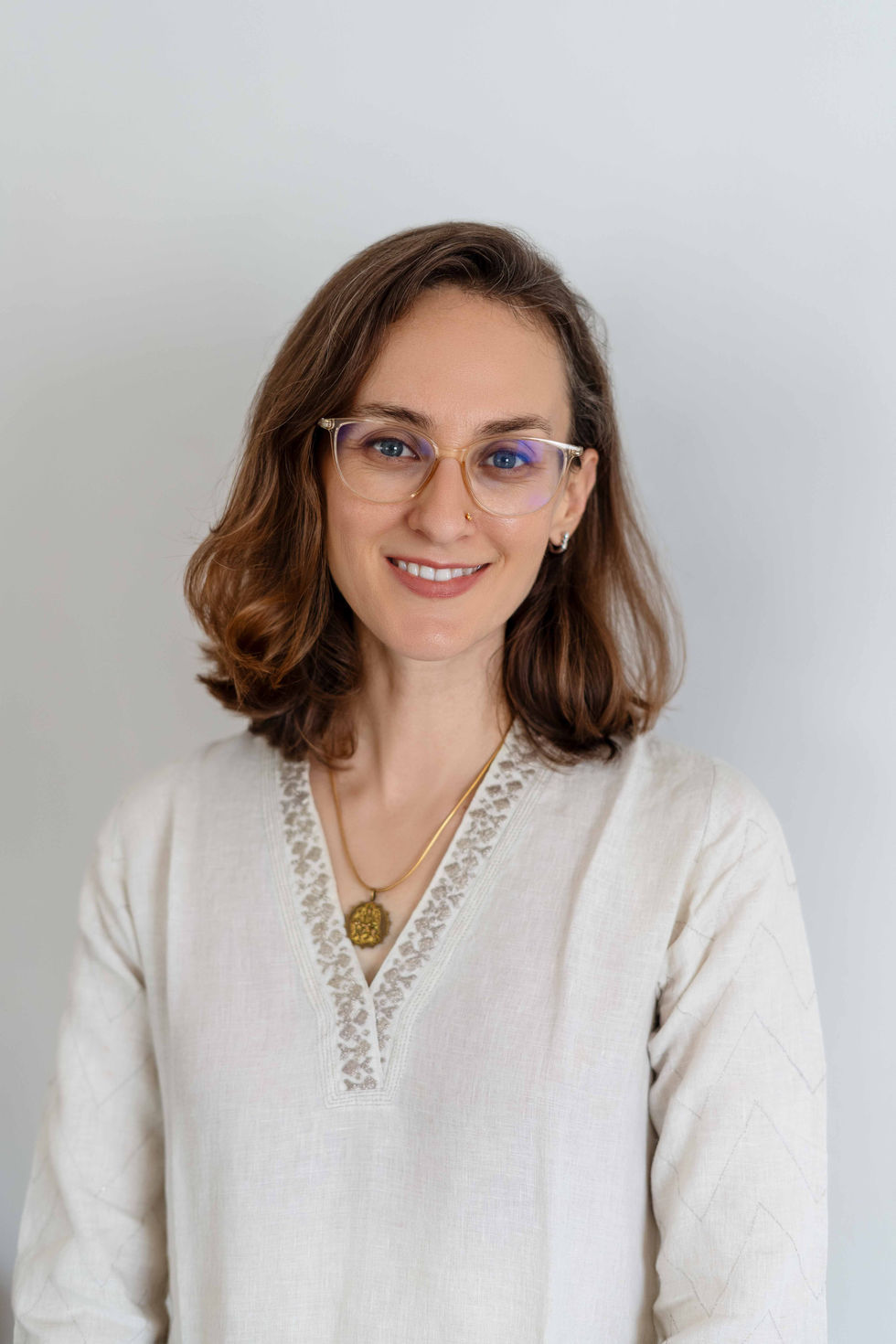 Smiling Ishani Lauren wearing glasses and a white top.