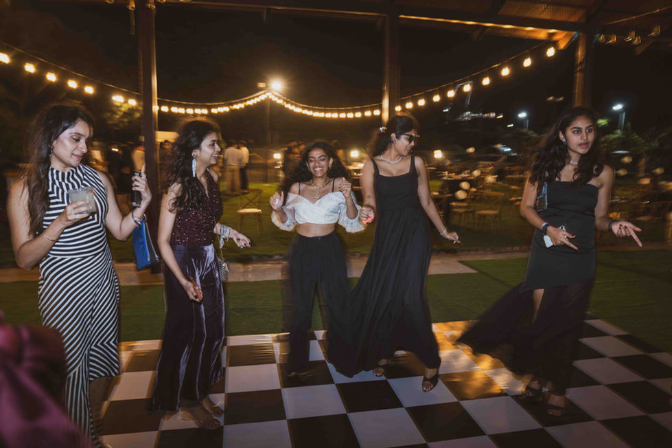 People dancing on a checkered floor at night.