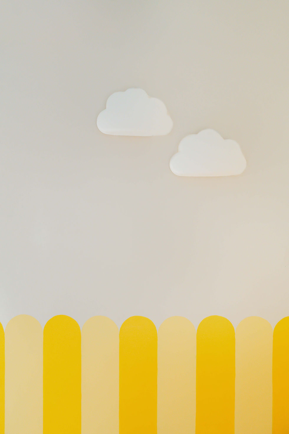 Minimalist design with clouds and yellow fence pattern.