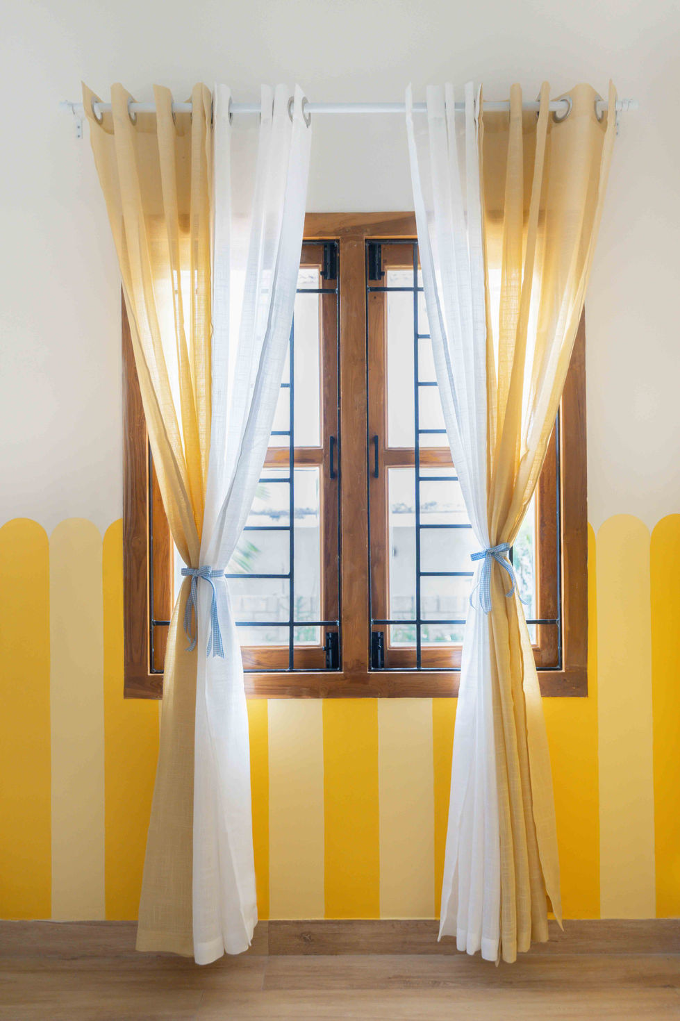 Yellow and white curtains on a window.