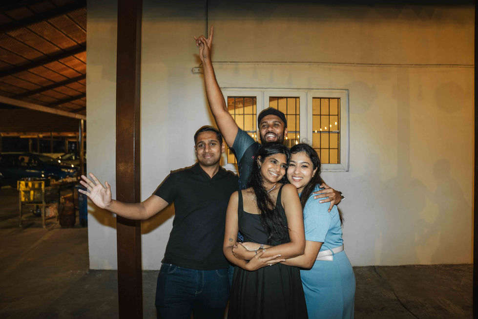 Four people posing happily in a group hug.