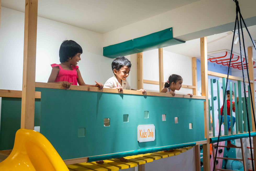 Children playing on indoor playground equipment.