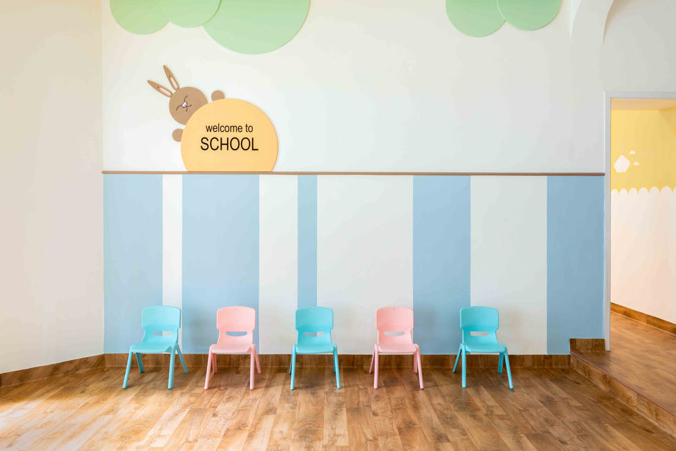 Colorful children's chairs under "Welcome to School" sign.